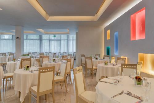 a dining room with white tables and chairs at Hotel Terme Venezia in Abano Terme