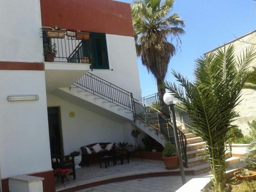 un edificio con scale e una palma in un cortile di Villa Margherita a Mazara del Vallo