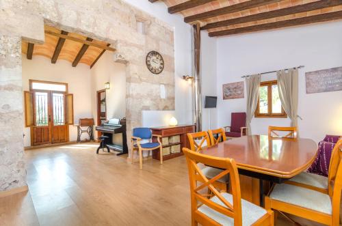 a dining room and living room with a table and chairs at Hort de Can Bou in Porreres