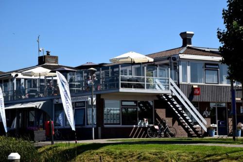 a large house with a porch and a balcony at TinyFloat Andijk in Andijk