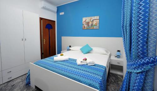 Un dormitorio azul con una cama con toallas. en B&B Cornelia, en Pompeya