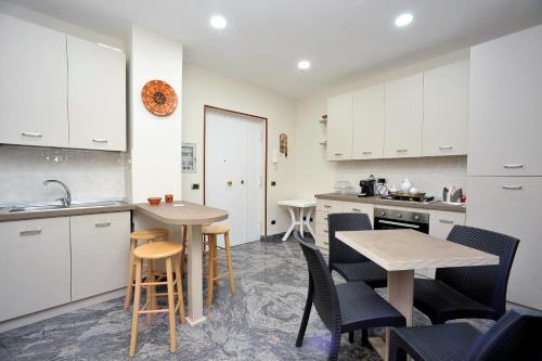 a kitchen with white cabinets and a table and chairs at B&B Cornelia in Pompei