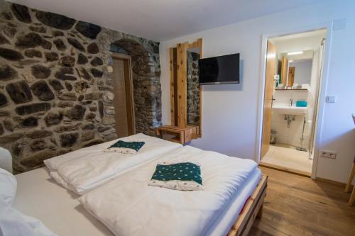 a bed in a room with a stone wall at Triebenerhof in Trieben