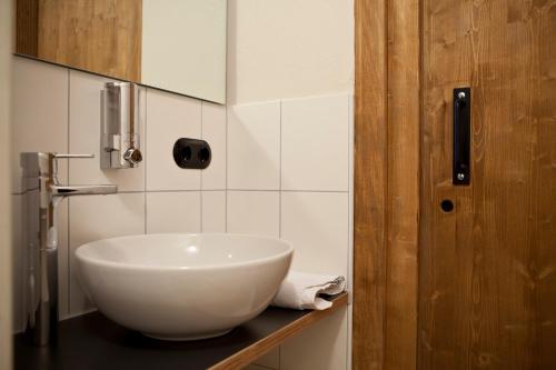 a bathroom with a white bowl sink on a counter at Wannenkopfhütte in Obermaiselstein