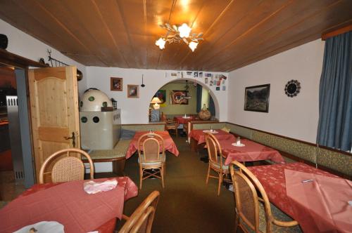 a restaurant with red tables and chairs and a stove at Haus Bergfrieden in Lermoos