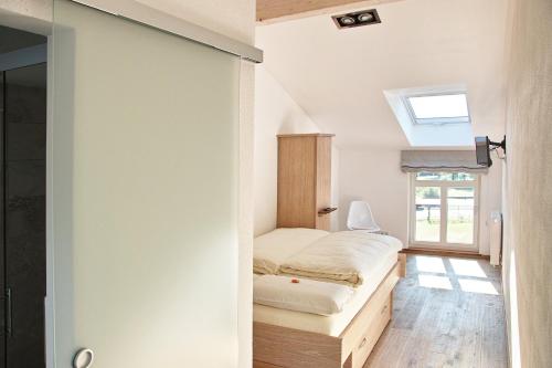 a small bedroom with a bed and a window at Kragemann Hotel & Vinothek in Simmerath