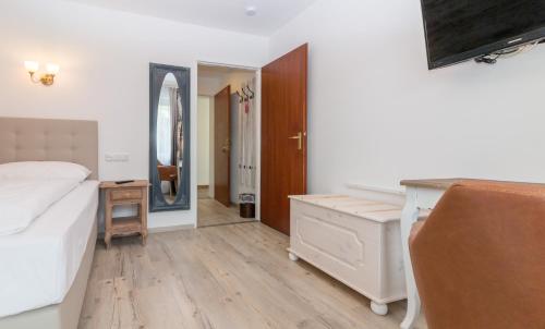 a bedroom with a bed and a dresser and a mirror at Hotel Diana Garni in Malente