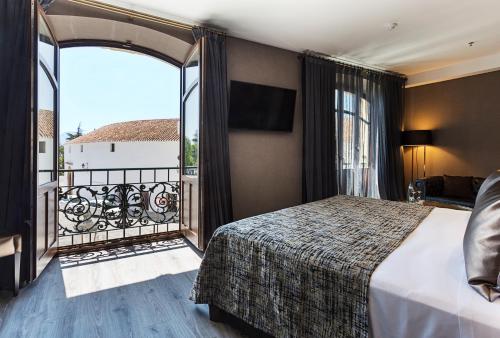 a hotel room with a bed and a balcony at Catalonia Ronda in Ronda