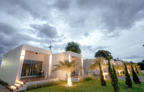 a white house with palm trees in front of it at West View Villa in Kanchanaburi