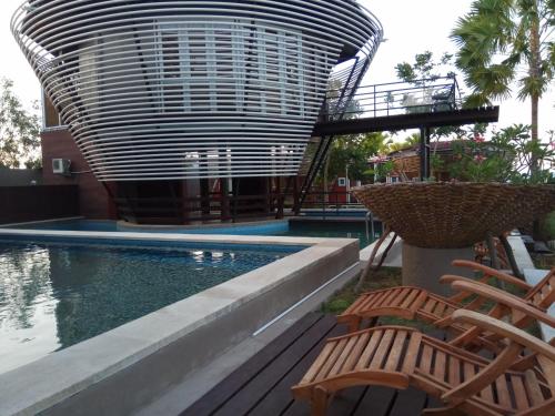 a pool with two chairs and a water slide at Bali Umah Tinjung in Tulamben