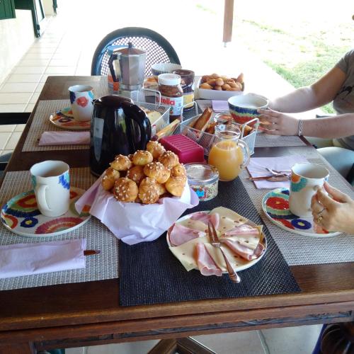 een tafel met een ontbijt van eten en sinaasappelsap bij La Mancine Laulan in Jau-Dignac-et-Loirac