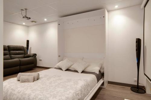 a bedroom with a large bed and a couch at Casa Los Pacos in Fuengirola