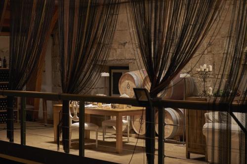 a table and chairs in a room with curtains at Hacienda Zorita Wine Hotel & Spa in Valverdón