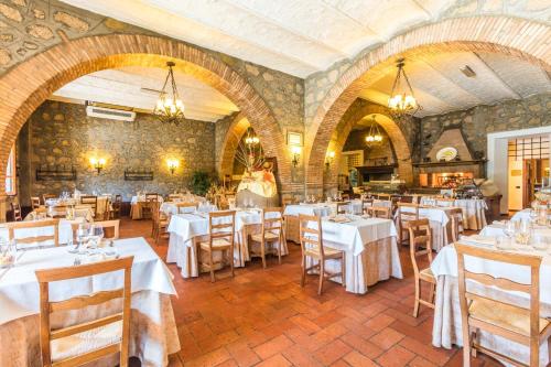 a restaurant with white tables and chairs in a room at Hotel Ristorante La Pergola in Magliano Sabina