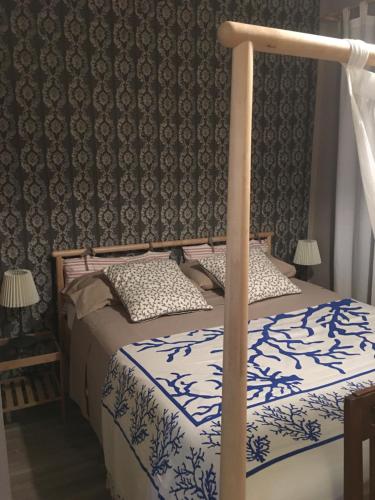 a bedroom with a bed with blue and white sheets at Bed & Breakfast Il mio Gelso in Villanova dʼAsti