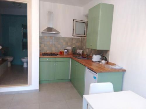 a kitchen with green cabinets and a sink at Casa Lucrino in Pozzuoli
