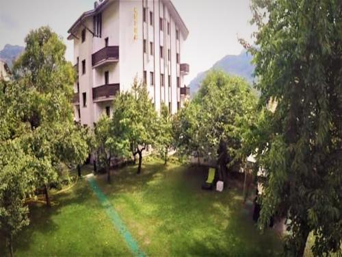 a building with a green lawn in front of a building at Hotel Au Soleil in Saint Vincent