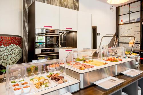 a kitchen with several trays of food on a counter at artHOTEL Magdeburg in Magdeburg