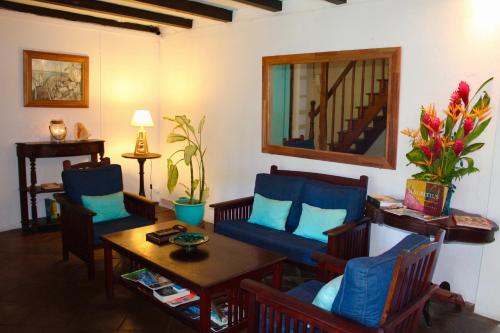 a living room with blue chairs and a table at Chantauvent Guest House in Blue Bay