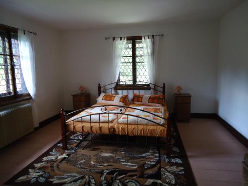 a bedroom with a bed with a rug and two windows at Apartment Chalet Kladska in Mariánské Lázně