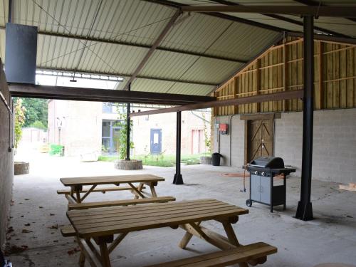 dos mesas de picnic en un edificio con parrilla en Modern Holiday Home in Fernelmont with Garden, en Forville
