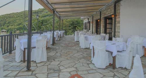a row of white tables and chairs on a patio at Pilio Sea Horizon Hotel in Tsagarada