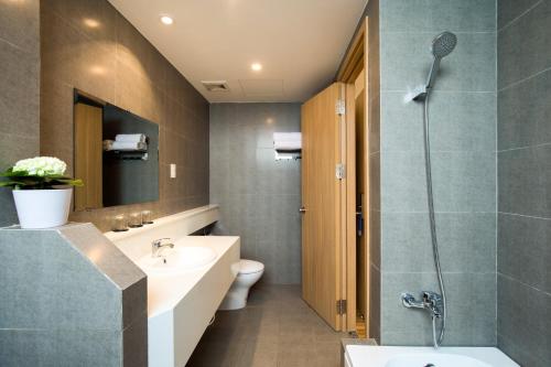 een badkamer met een wastafel, een toilet en een douche bij Gaia Hotel Phu Quoc in Phu Quoc