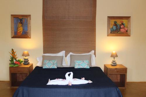 a bedroom with a bed with two swans on it at Chantauvent Guest House in Blue Bay