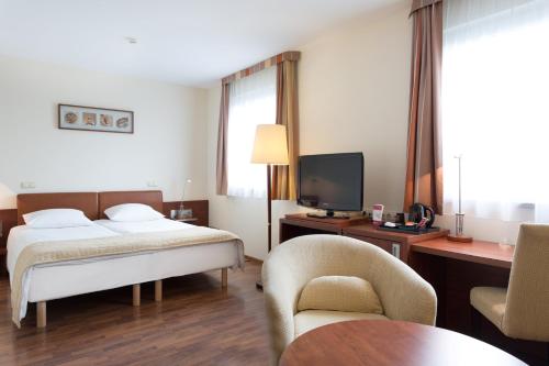 a hotel room with a bed and a tv at Qubus Hotel Gliwice in Gliwice