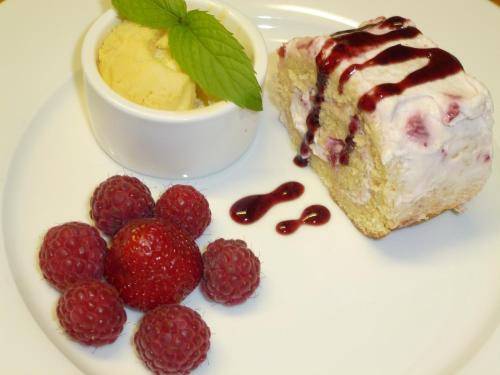 a white plate with a piece of cake and strawberries at Ubytovanie u Janusa in Levoča