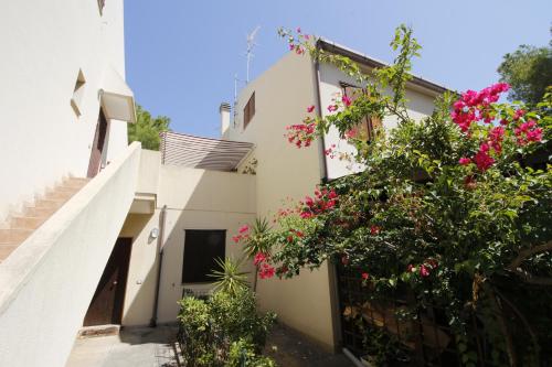 a house with pink flowers on the side of it at I Ginepri in Sorso