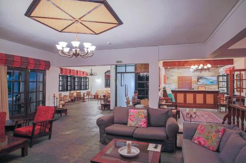 a living room with couches and tables and a chandelier at Pilio Sea Horizon Hotel in Tsagarada