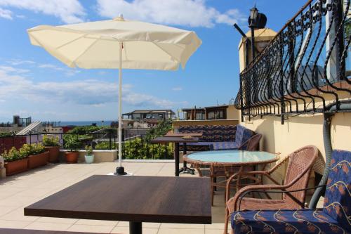 un patio con mesas y una sombrilla en el balcón en Hotel Peninsula, en Estambul