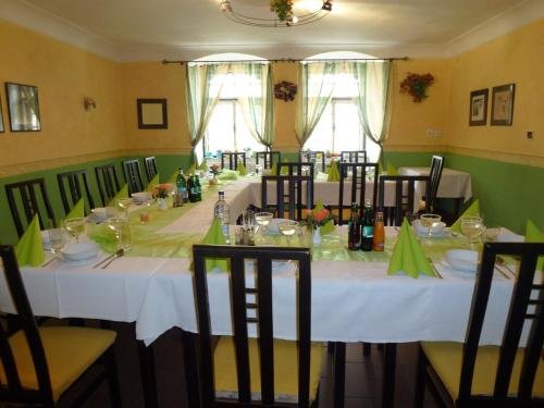 a long table with white tables and chairs in a room at Ubytovanie u Janusa in Levoča