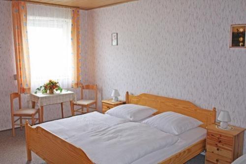Gasthof zur Krone في Burghaslach: غرفة نوم بسرير وطاولة ونافذة