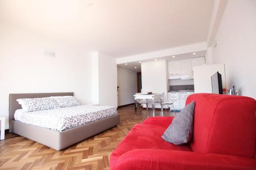 ein Schlafzimmer mit einem Bett und einem roten Sofa in der Unterkunft Casa Vacanze Finestra del Pescatore in Marone