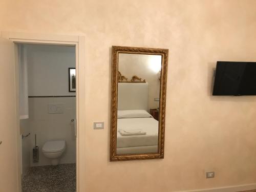 a mirror on the wall of a bathroom with a toilet at Hotel "La Salute" in Monte Grimano Terme