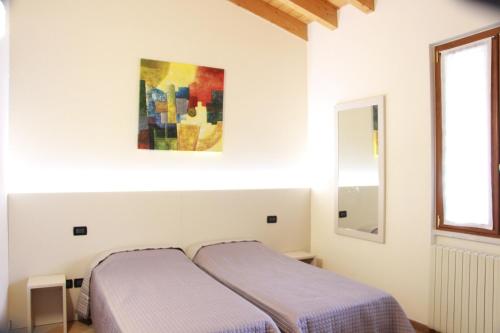 una camera con due letti e un dipinto sul muro di Villa Pasini a Provaglio d'Iseo