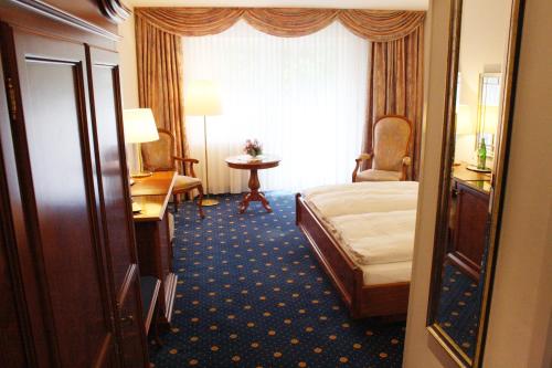 a hotel room with a bed and a table at Hotel König-Stuben in Bispingen