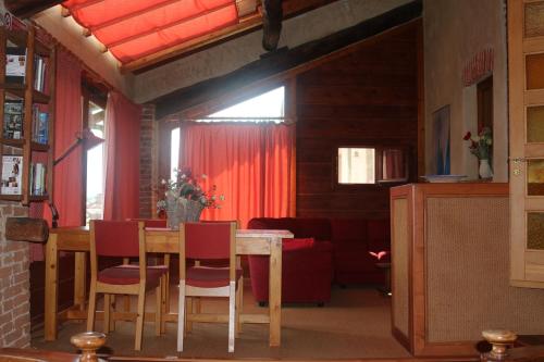 comedor con mesa y cortinas rojas en Locanda Dei Gelsi, en Villar San Costanzo