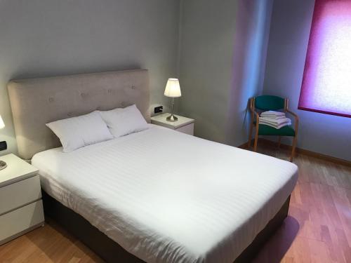バレンシアにあるApartamentoS MARINA BEACHのベッドルーム(大きな白いベッド1台、椅子付)