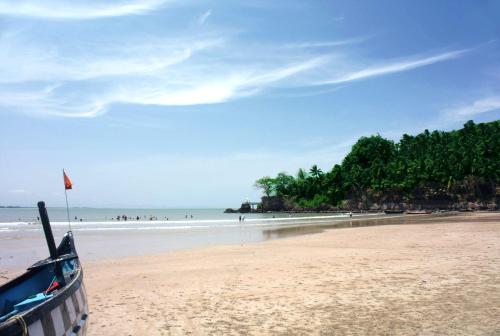 a boat on a beach with people in the ocean at Devasthali - The Valley of Gods in Bogmolo