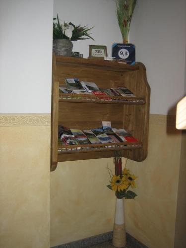 a shelf on the wall with magazines and a vase at Residence Casa Federica in Valfurva