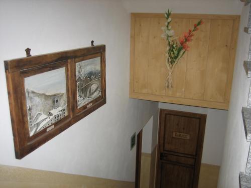 a picture on a wall with a vase of flowers at Residence Casa Federica in Valfurva