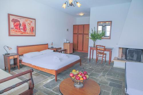 a bedroom with a bed and a table with a bowl of fruit at Pilio Sea Horizon Hotel in Tsagarada