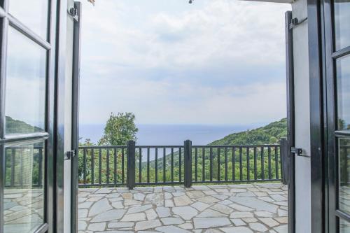 an open door to a balcony with a view of the ocean at Pilio Sea Horizon Hotel in Tsagarada
