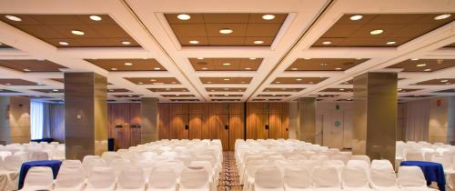 a room with rows of white chairs in a hall at SH Valencia Palace in Valencia