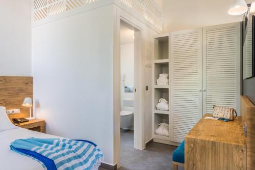 Un dormitorio con una cama y un baño con bañera. en Stellina Village, en Kato Daratso