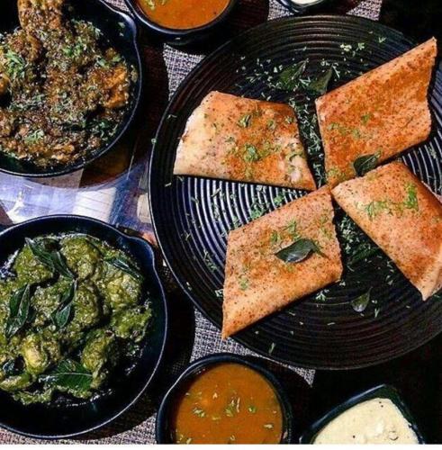 a table topped with plates of food with different types of food at Zense Candolim in Candolim
