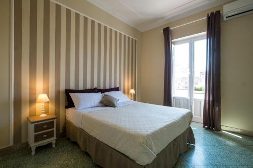 una camera con un letto e una grande finestra di Mille e una Notte / Station Apartment a Palermo